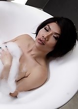 Zena Lynn in a bubbly tub jacking off her dick until she cums hard